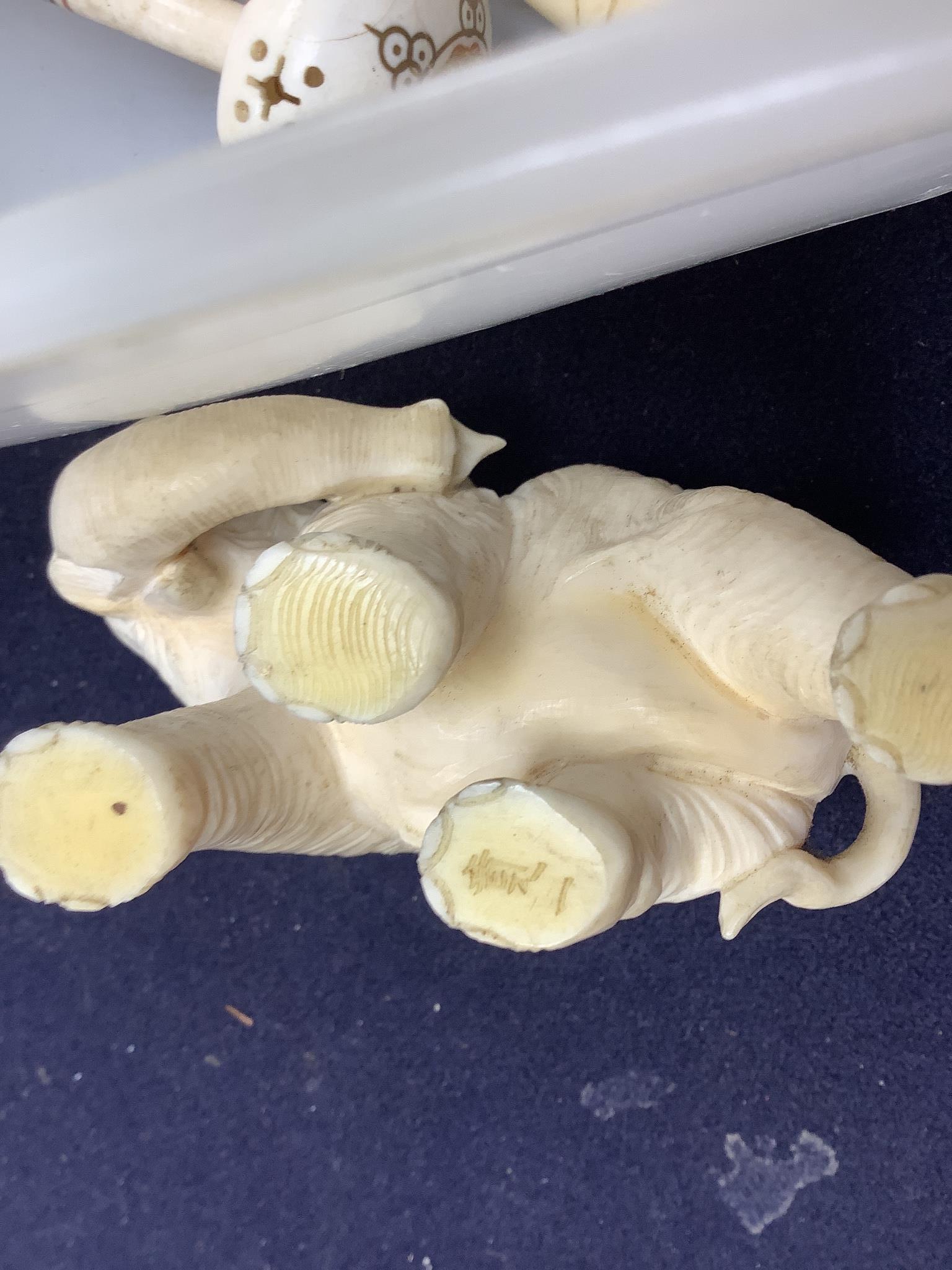 A Japanese Ivory okimono of an elephant, signed, an ivory gavel (incomplete) and two other Ivory carvings, 19th/early 20th century